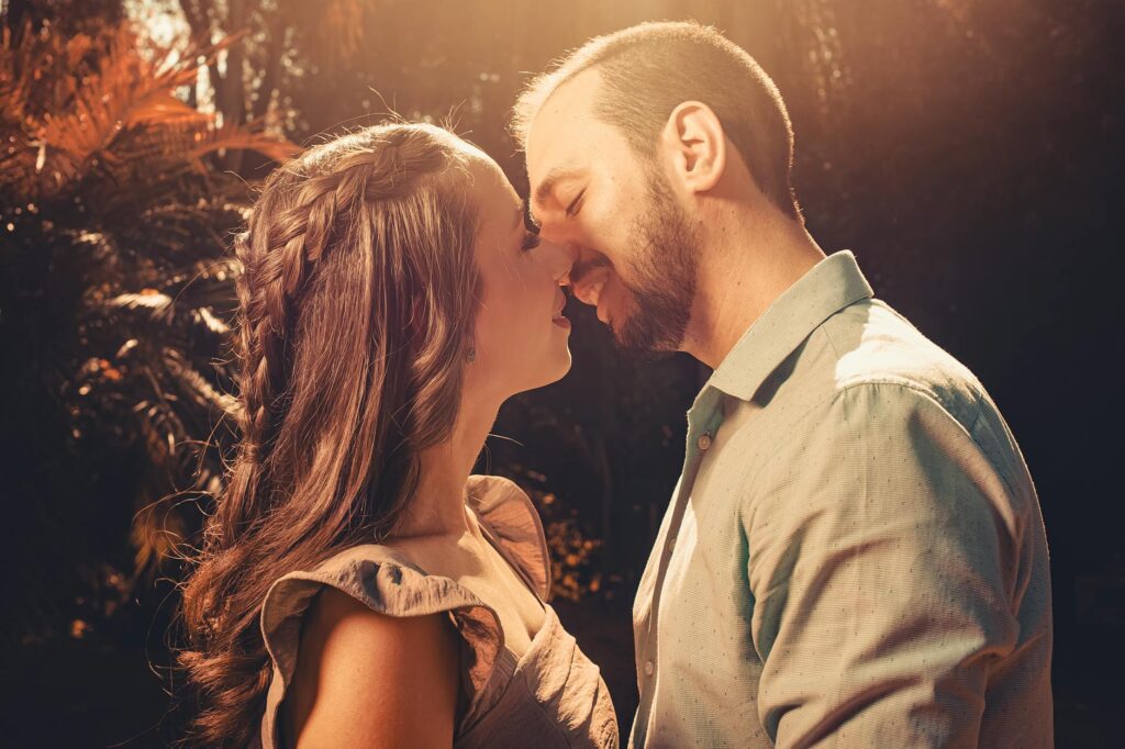 romantic couple kissing in sunlit garden